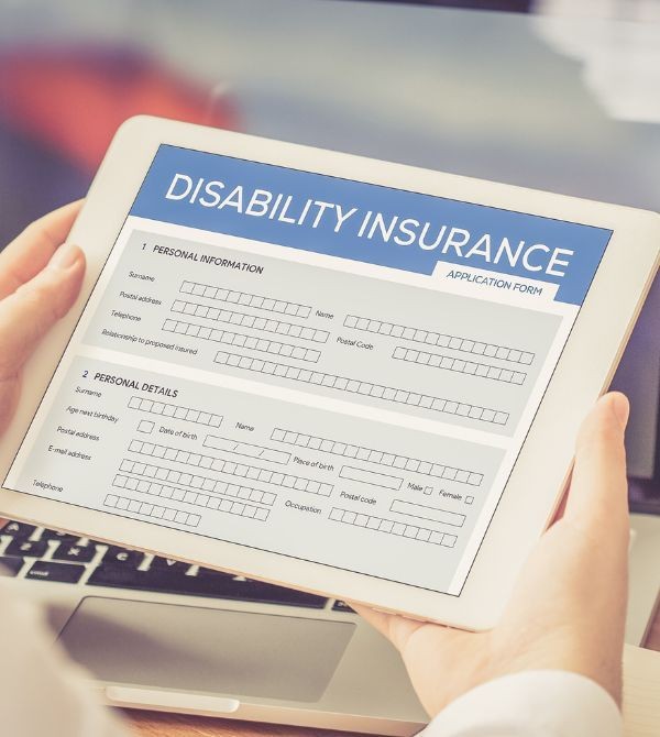 Person holding a tablet displaying a disability insurance application form with sections for personal information and details.