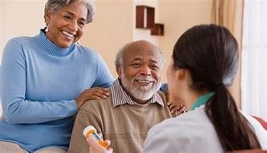 Healthcare professional holding a pill bottle while discussing medication with an elderly couple at home.