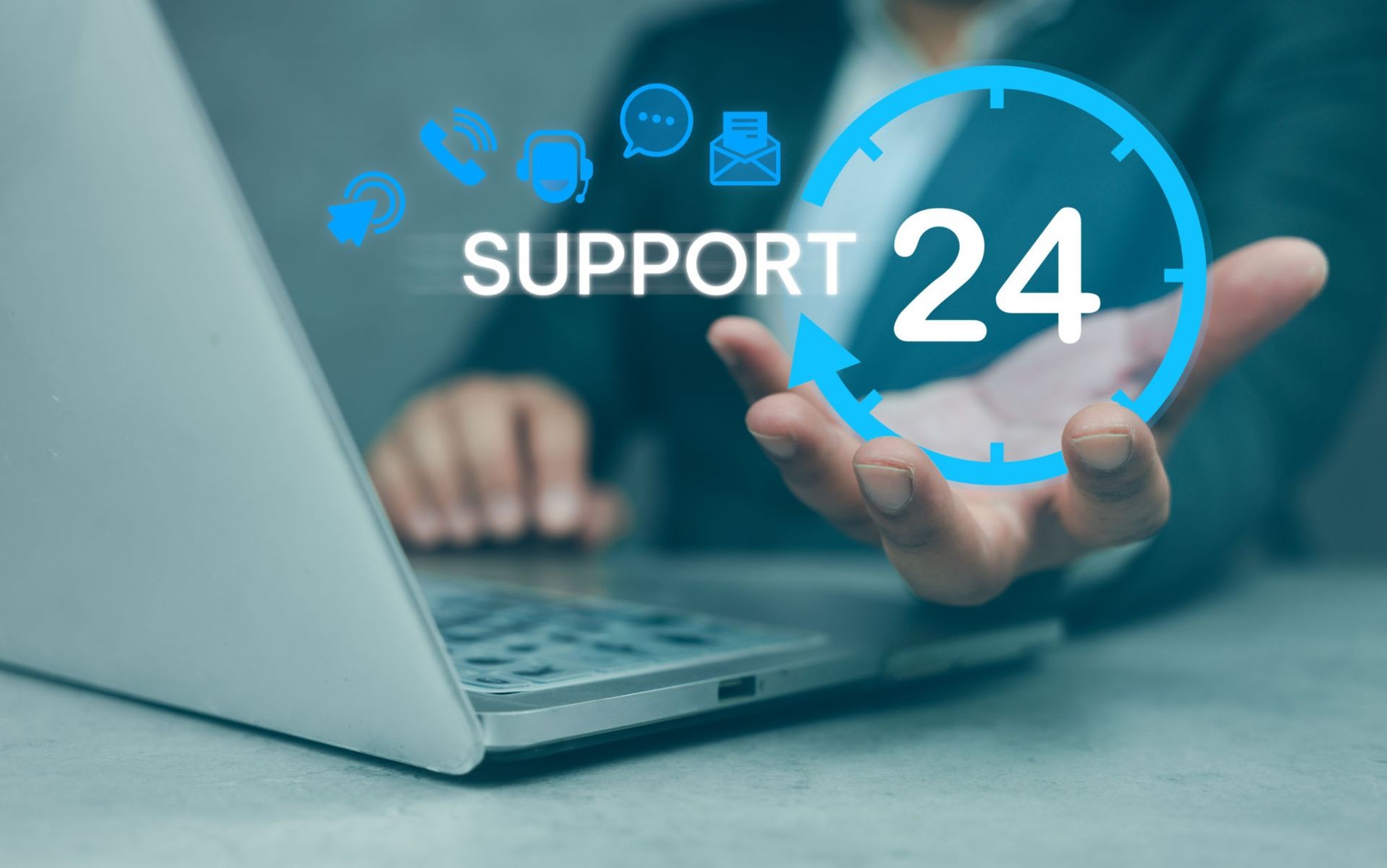 Person holding a graphic of 24/7 support service icons in front of a laptop computer.